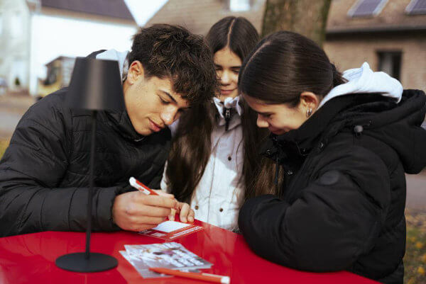 Jugendliche im Gespräch am roten Tisch