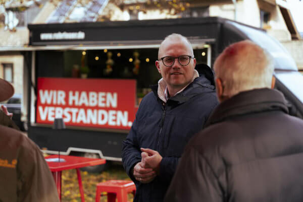 Mann im Gespräch vor dem Verstanden-Truck
